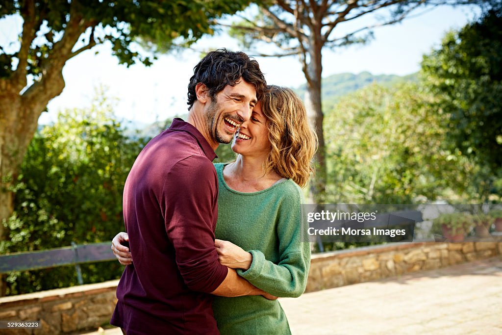 Cheerful couple embracing in park