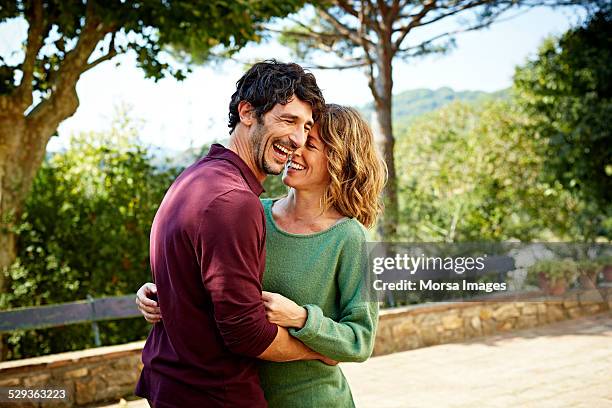 cheerful couple embracing in park - two imagens e fotografias de stock