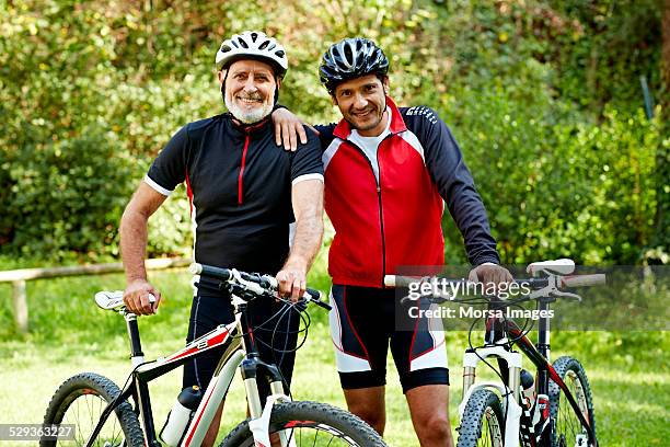 father and son with bicycles in park - cycling helmet stock pictures, royalty-free photos & images