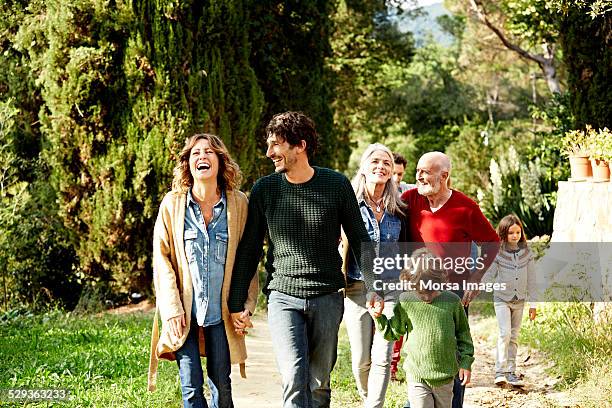 happy family walking in park - walking photos et images de collection