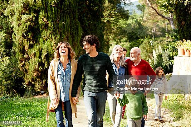 happy family walking in park - multi generation family outdoor stockfoto's en -beelden