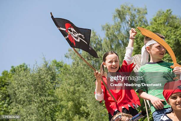 girl holding pirate flag with her friends in adventure playground, bavaria, germany - fake of indian girls stock pictures, royalty-free photos & images