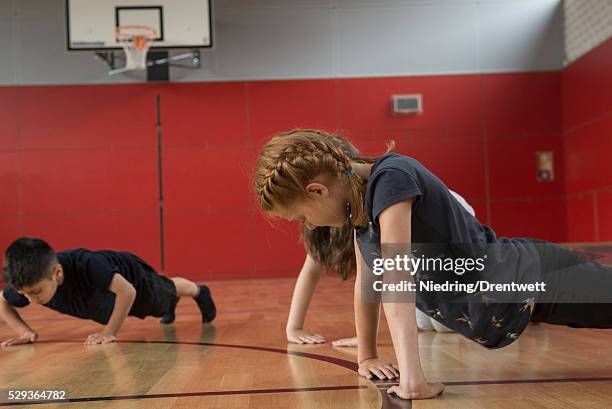 children doing press-ups in sports hall, munich, bavaria, germany - kurdish girl - fotografias e filmes do acervo