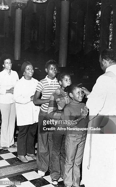 African-American children in a church during an Ash Wednesday event Original Caption Reads: 'Ash Wednesday'.