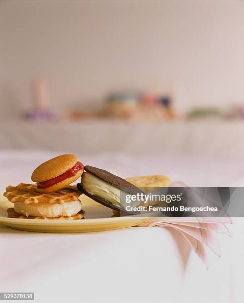 view of ice cream sandwhiches stacked on a plate, on edge of a table - food table edge stock-fotos und bilder