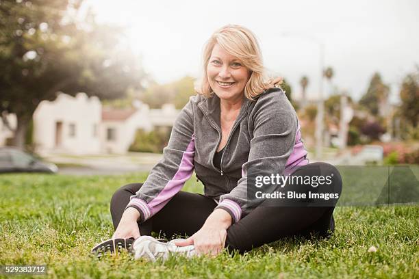 portrait of woman exercising on lawn - mid adult stock pictures, royalty-free photos & images