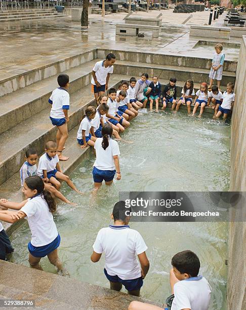 children playing in the water features at the parque de los pies descalzos (barefoot park) - medellin photos et images de collection