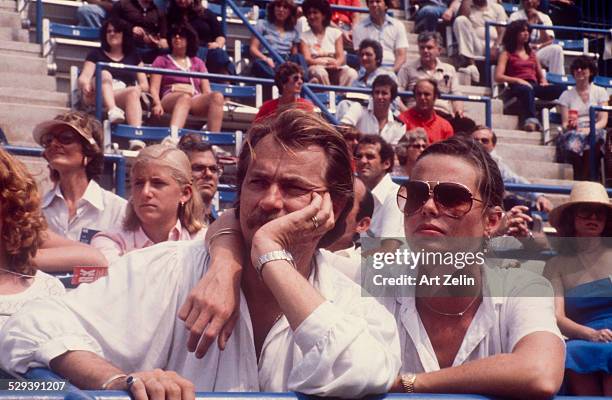 Margaux Hemingway in aviator sunglasses with a friend watching a tennis match; circa 1970; New York.