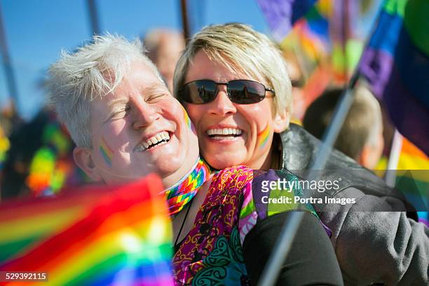 couple laughing in gay parade - gay flag stock-fotos und bilder