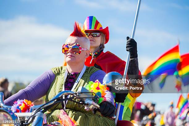 couple riding bike during gay pride parade - gay pride parade stock pictures, royalty-free photos & images