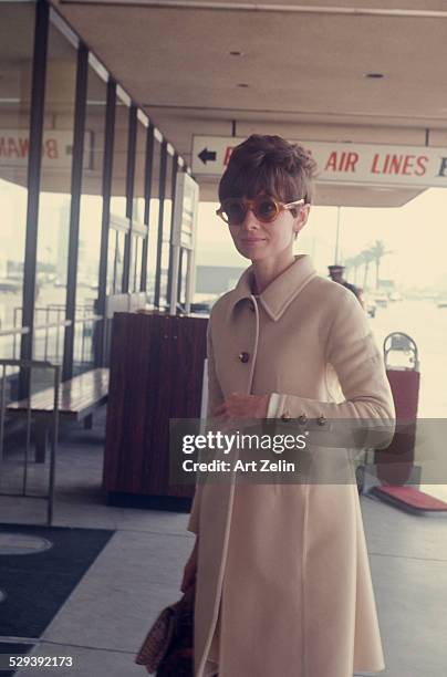 Audrey Hepburn wearing a beige wool coat and sunglasses at the airport; April 1st 1968 ; New York.