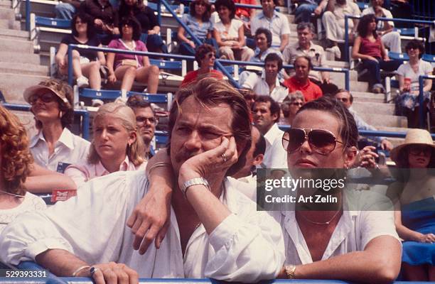 Margaux Hemingway in aviator sunglasses with a friend watching a tennis match; circa 1970; New York.