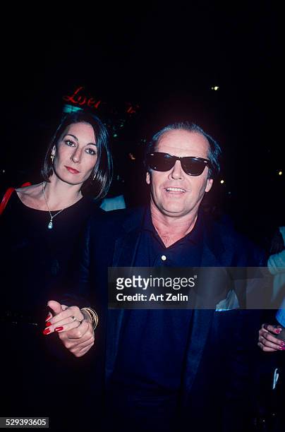 Jack Nicholson with Anjelica Huston both in black holding hands; circa 1970; New York.