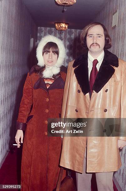 Rob Reiner with his wife Penny Marshall in a hallway. He is wearing a fur trimmed leather coat she is wearing a rust colored suede coat and fur hat;...