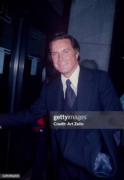 Cliff Robertson in a pinstriped suit going into a building; circa 1970; New York.