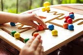 Child playing with wooden pathfinder toy board