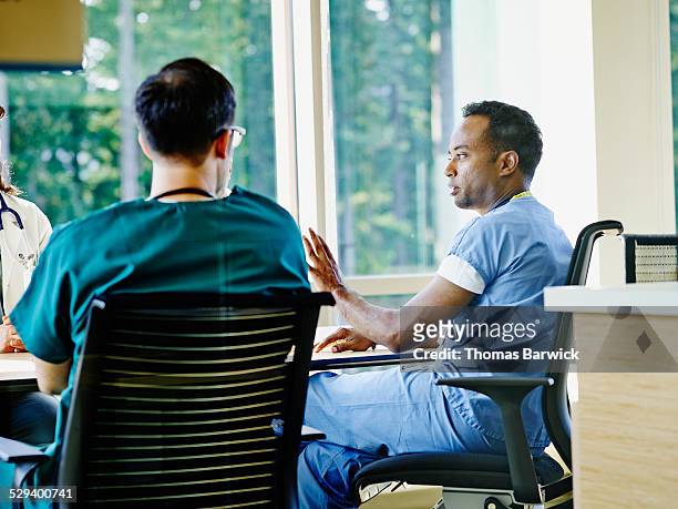 surgeon leading discussion with colleagues - health authority stock pictures, royalty-free photos & images