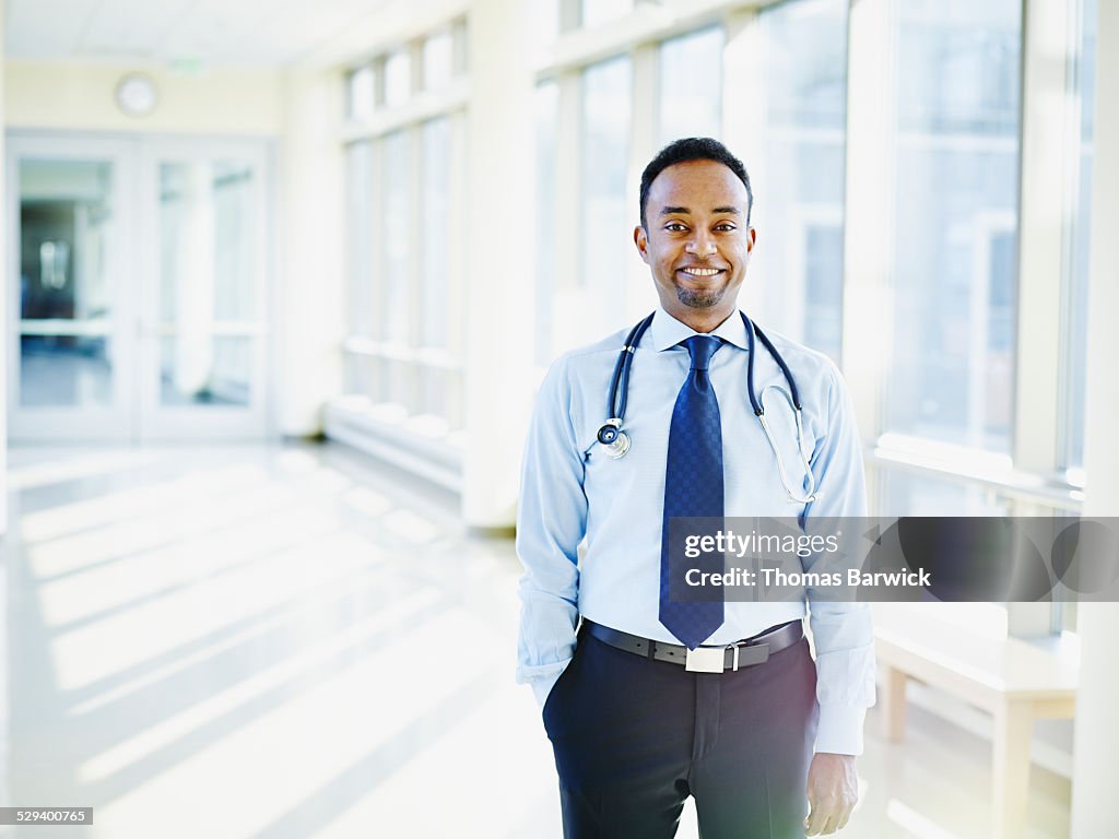 Smiling doctor standing in corridor of hospital