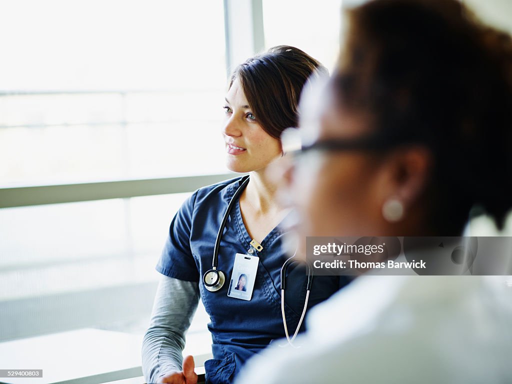 Female nurse listening during medical team meeting