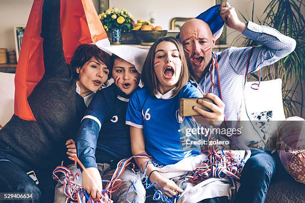 français famille les fans de football regarder match de football sur un smartphone - happy famille france photos et images de collection