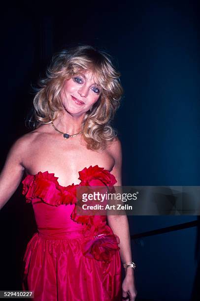 Goldie Hawn in a red ruffled strapless formal dress; circa 1970; New York.