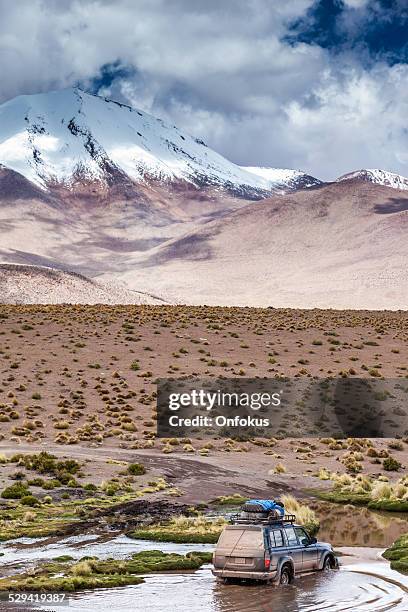 suv de cruzar el río en el altiplano boliviano - licancabur fotografías e imágenes de stock