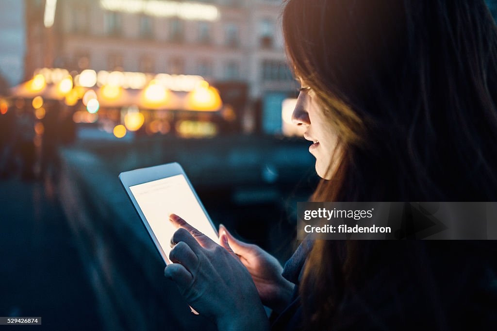 Woman using tablet at night