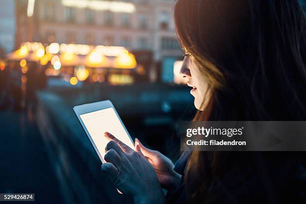 woman using tablet at night - pda stock pictures, royalty-free photos & images