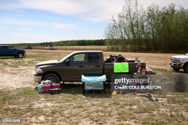 Lisa Leclair and Jared Ward set up their free goods and essentials stop in Wandering River, Alberta, while their baby son Jayden plays in his pen on...