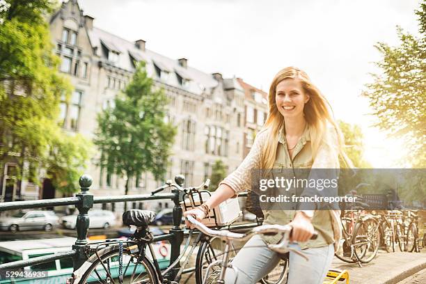 woman tourist cycling on amsterdam - vrouw fiets stockfoto's en -beelden