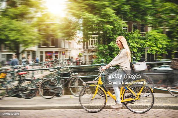 woman tourist cycling on amsterdam - amsterdam bike stockfoto's en -beelden