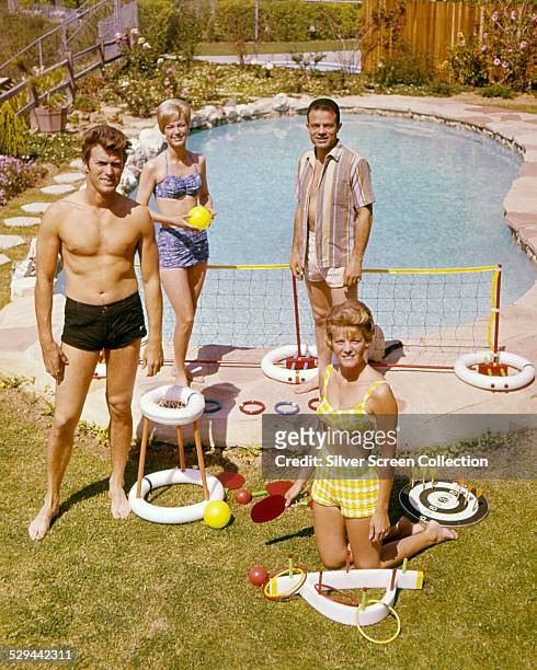 American actor Clint Eastwood with his wife, Maggie , and friends by a swimming pool, circa 1960.