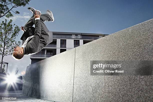 man jumping near concrete wall - achterwaartse salto stockfoto's en -beelden