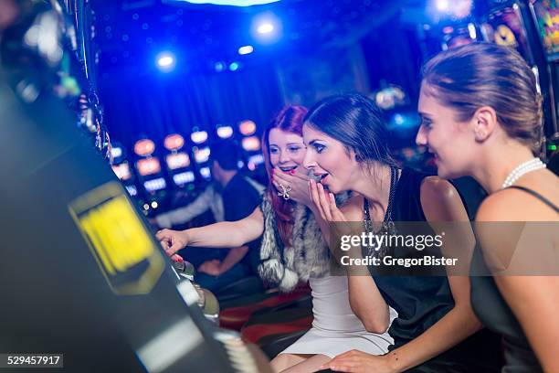 woman in a casino winning at slot machine - teen pokies stock pictures, royalty-free photos & images