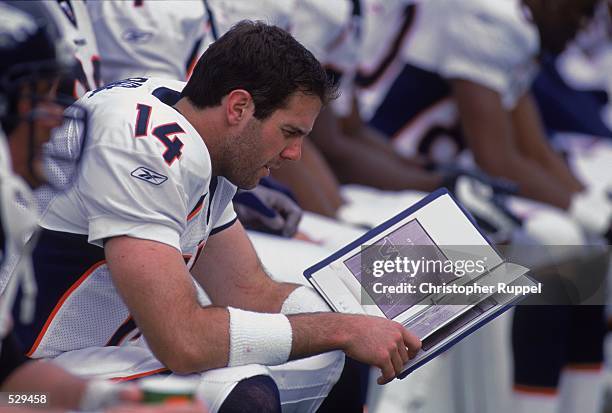 Brian Griese of the Denver Broncos reads a playbook during the game against the Seattle Seahawks at the Husky Stadium in Seattle, Washington. The...