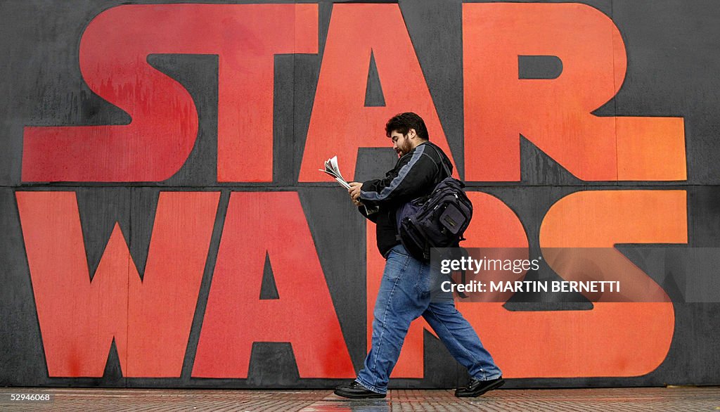 A man walks past a poster promoting the