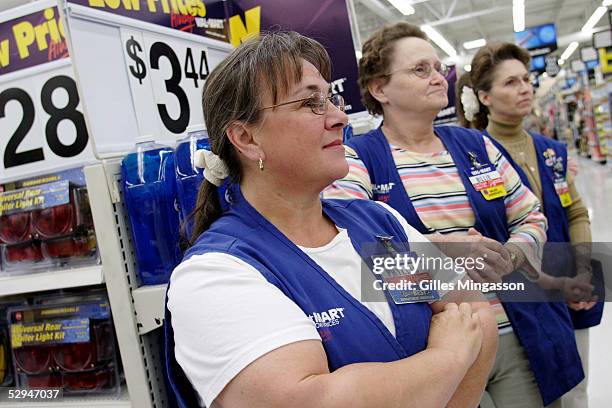 Female Wal-Mart employees look on as a manager rewards an employee with a plaque, a common practice in the company on March 16, 2005 in Bentonville,...