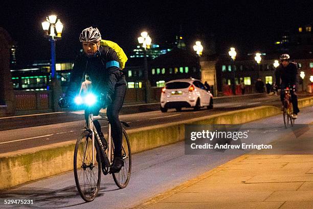 England, London, Southwark Bridge, man riding bicycle at night. Blurred motion.