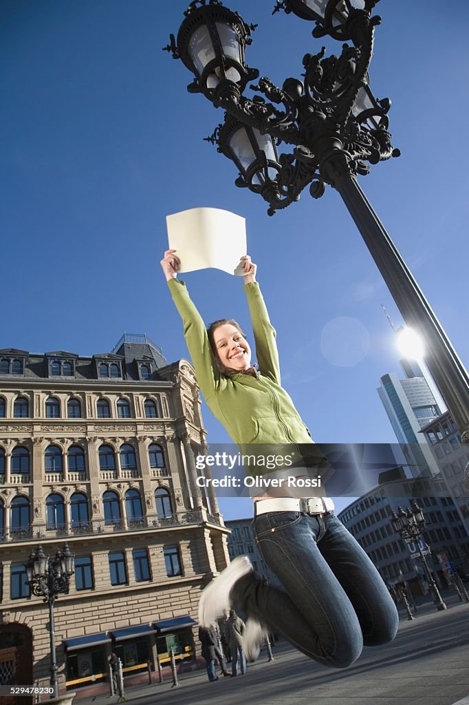 Teen girl jumping with sign