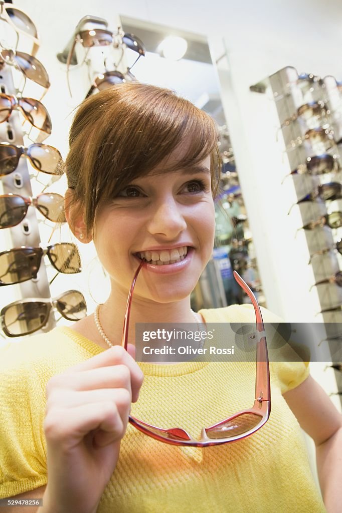 Teen girl holding sunglasses in store