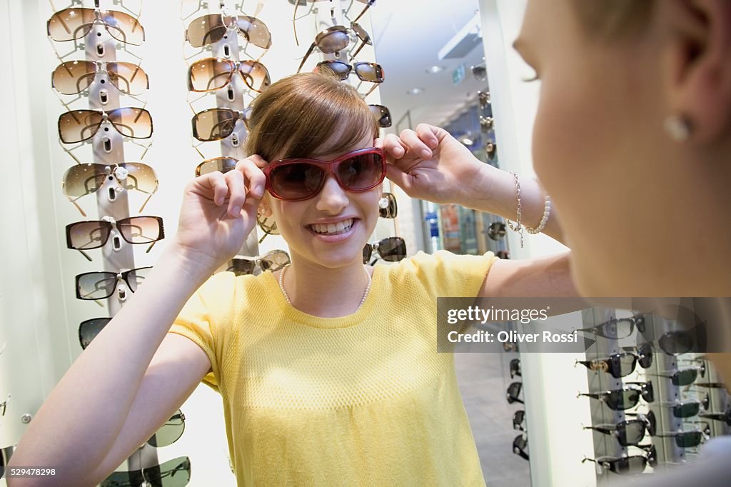 Teen girl trying on sunglasses