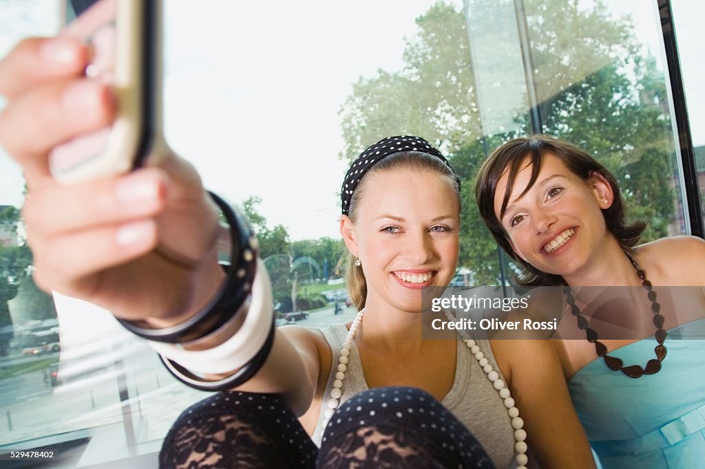 Teen girls taking pictures with cell phone