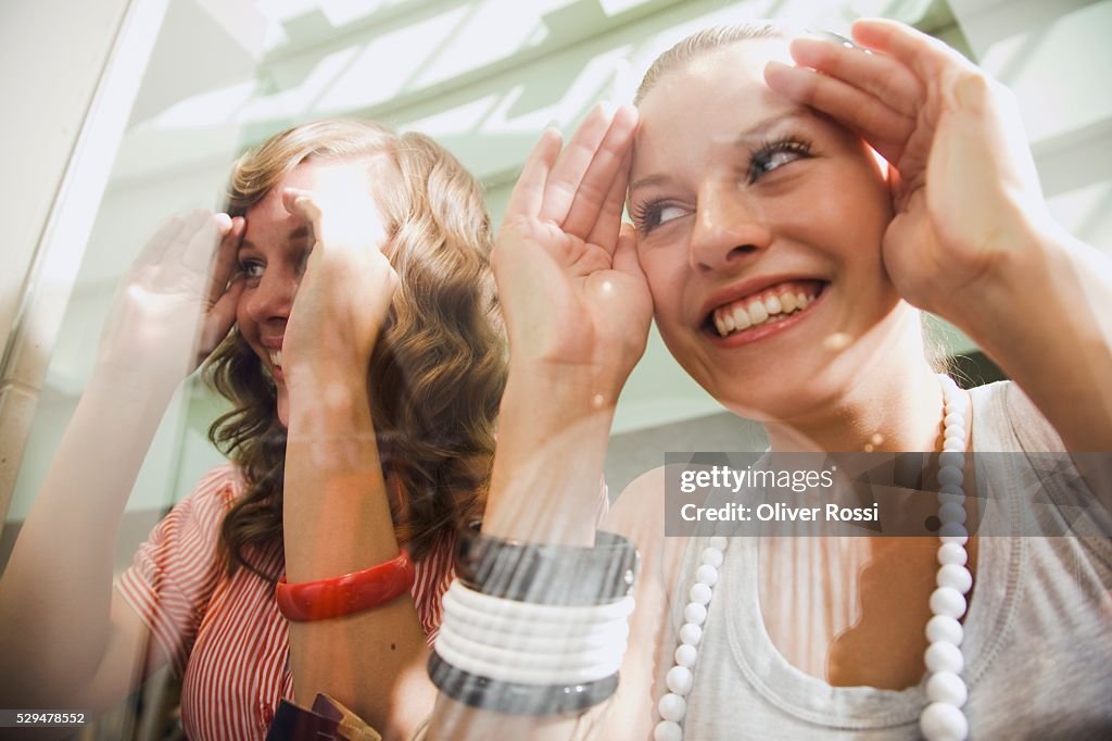 Teen girls looking through shop window