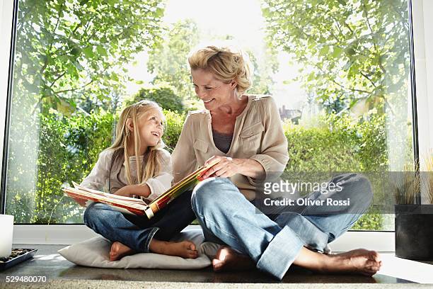 grandmother and granddaughter reading together - granddaughter ストックフォトと画像
