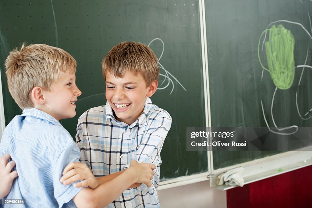 Boys playing in front of blackboard