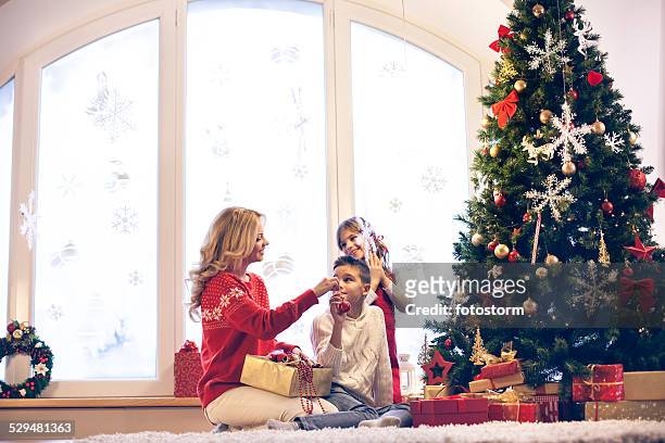 family decorating christmas tree - family decorating stock pictures, royalty-free photos & images