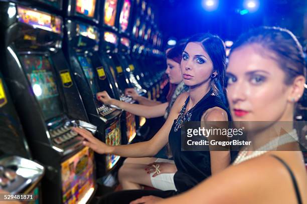 friends gambling in the casino on slot machines - teen pokies stock pictures, royalty-free photos & images