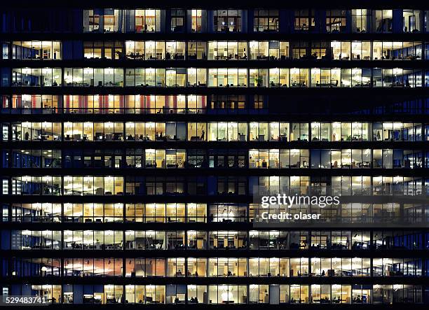 lavoratori che lavorano fino a tardi. ufficio windows per notte. - working late foto e immagini stock