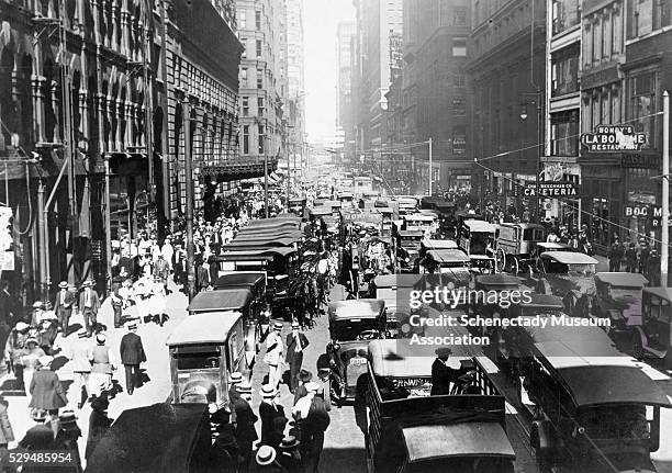 Street in Chicago is chaotic and crowded before the implementation of a "No Parking" order and the installation of electric traffic lights.