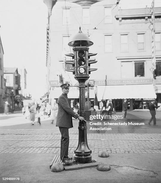 Traffic officer operates a three section traffic control signal equipped with a T-16 pole and control box.